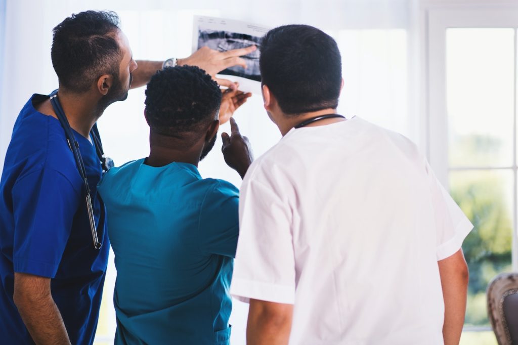 doctor and assistants looking at teeth xray